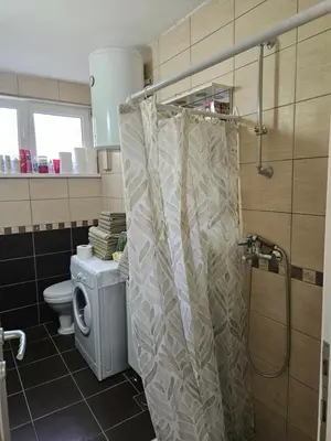 a bathroom with a shower curtain and a toilet at K&N centar Doboj in Doboj