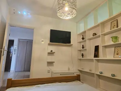 a bedroom with a flat screen tv and shelves at K&N centar Doboj in Doboj