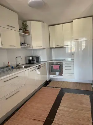 a kitchen with white cabinets and a sink at Bambi Zenica in Zenica