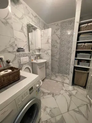 a bathroom with a washing machine and a sink at Bambi Zenica in Zenica