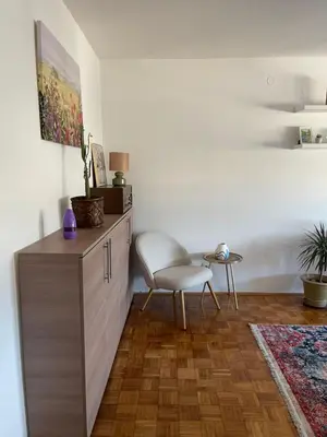 a living room with a chair and a cabinet at Bambi Zenica in Zenica