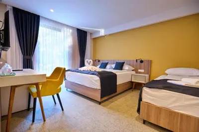 a hotel room with two beds and a desk at Hotel Luna Bihać in Bihać