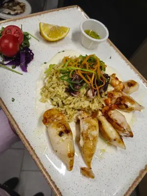 a plate of food with fish and rice on a table at Hotel Luna Bihać in Bihać