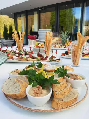 a table with a plate of bread and bowls of food at Hotel Luna Bihać in Bihać