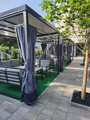 a patio with tables and chairs under a canopy at Hotel Luna Bihać in Bihać