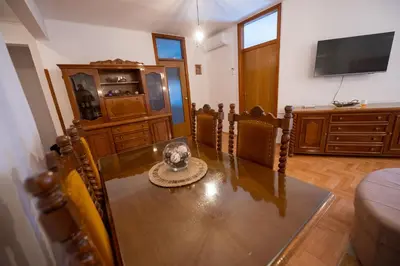 a dining room with a table and a tv at Apartman Magija in Banja Luka