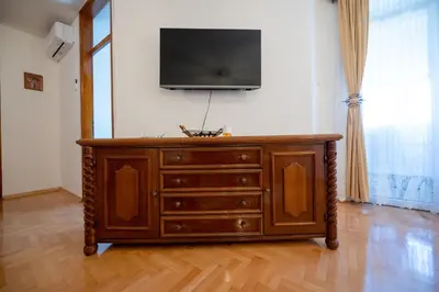 a wooden dresser with a television on top of it at Apartman Magija in Banja Luka