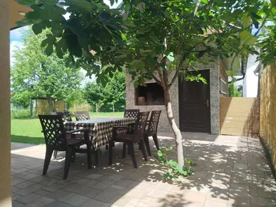 a table and chairs under a tree on a patio at Villa Orhan in Bihać
