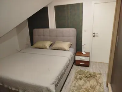 a bedroom with a bed and a night stand and a door at Villa Orhan in Bihać