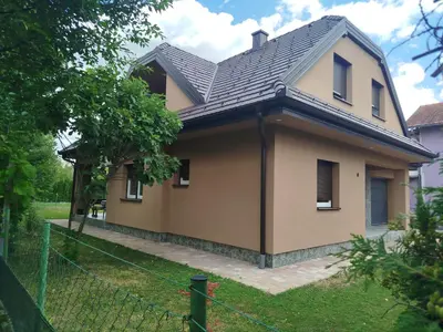 a house with a black roof and a fence at Villa Orhan in Bihać