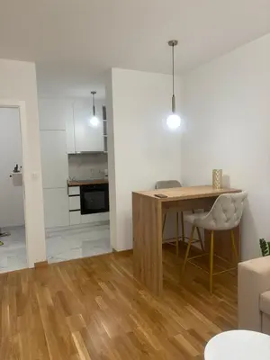 a living room with a dining room table and a kitchen at Apartman ADA in Železnička Stanica Incel