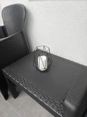 a black table with a candle and a chair at Apartman ADA in Železnička Stanica Incel