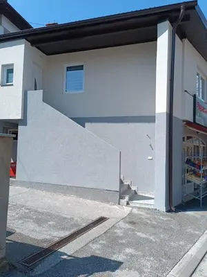 a building with an open garage door with a staircase at Apartman Zana in Visoko