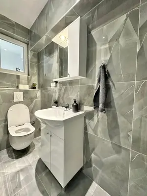 a bathroom with a white sink and a toilet at Apartman Zana in Visoko