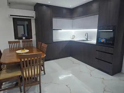 a kitchen with a wooden table and a dining room at Apartmani Mikić in Bosanski Šamac