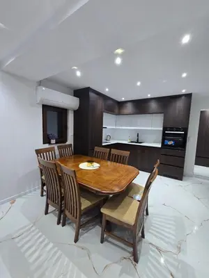 a dining room with a wooden table and chairs at Apartmani Mikić in Bosanski Šamac