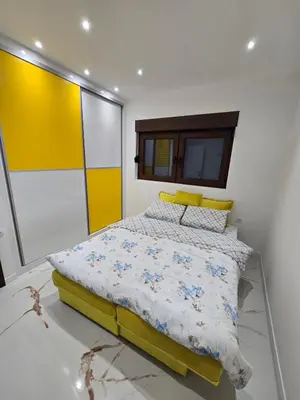 a bedroom with a bed with a yellow headboard at Apartmani Mikić in Bosanski Šamac