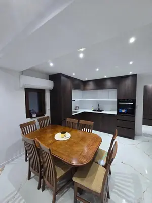 a kitchen and dining room with a wooden table and chairs at Apartmani Mikić in Bosanski Šamac