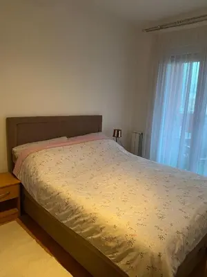 a bedroom with a large bed with a window at Apartman Nasic in Bihać