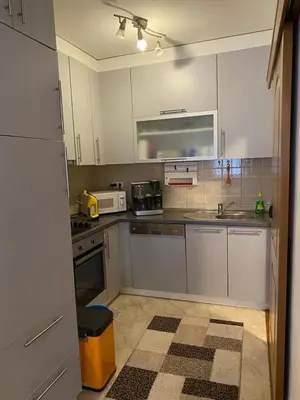 a kitchen with white cabinets and a stove top oven at Apartman Nasic in Bihać