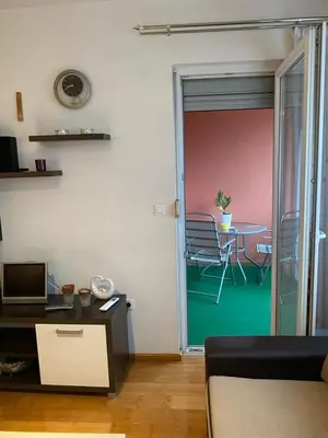 a living room with a door open to a dining room at Apartman Nasic in Bihać