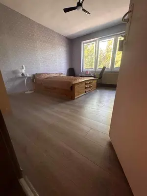 a bedroom with a bed and a desk and a window at KONAK kod ODISEJE in Tuzla