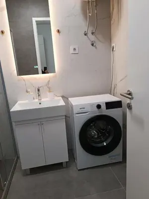a bathroom with a washing machine and a sink at Elena - stan na dan in Banja Luka