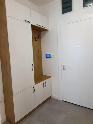 a kitchen with white cabinets and a door at Elena - stan na dan in Banja Luka