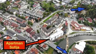 an aerial view of a city with a red arrow pointing to an apartment suburb at Apartman Sofija centar in Teslić