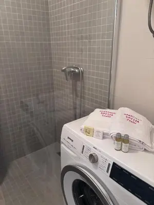 a washing machine in a bathroom with a shower at Apartman Sofija centar in Teslić