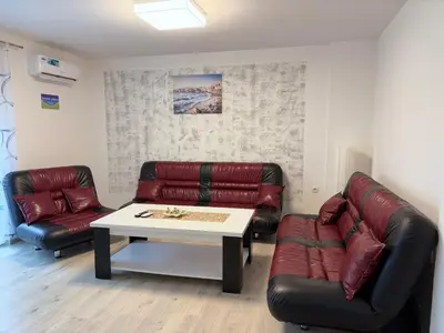 a living room with two leather couches and a table at Apartman Sofija centar in Teslić