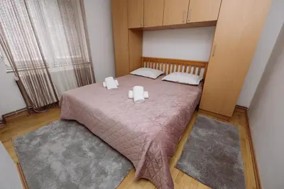 a bedroom with a bed with two candles on it at Apartman Eni in Livno