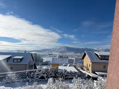 a snow covered city with houses and mountains at Apartman Eni in Livno