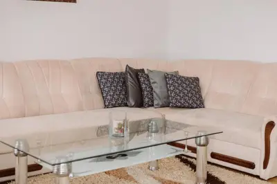 a white couch with pillows and a glass coffee table at Apartman Eni in Livno