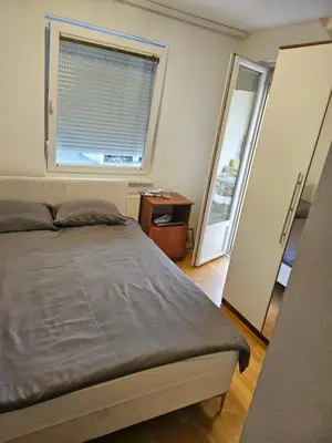 a bedroom with a bed and a large window at Apartman Dona in Bosanska Gradiška