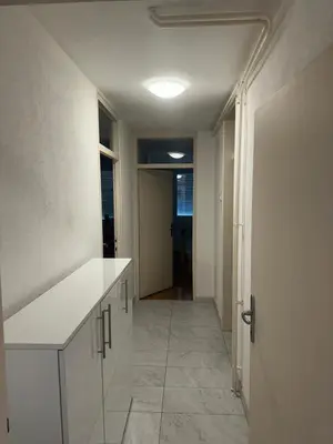 a kitchen with a white counter and a hallway at Stan in Zenica