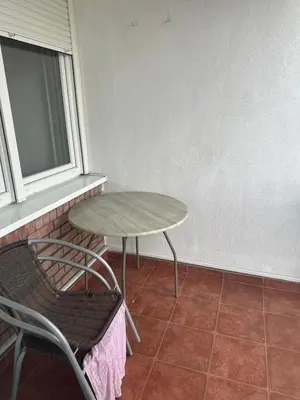 a table and chair in a room with a window at Stan in Zenica