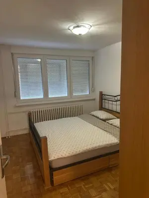a bedroom with two beds and two windows at Stan in Zenica