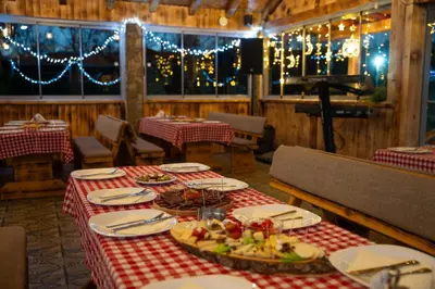 a table with plates of food on it in a restaurant at EJDE RESORT Šiljkovača in Velika Kladuša