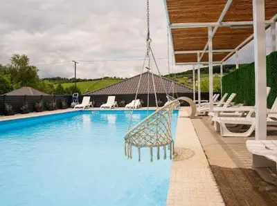 a hammock is hanging over a swimming pool at EJDE RESORT Šiljkovača in Velika Kladuša