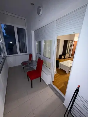 a living room with a red chair and a table at San apartment in Banja Luka