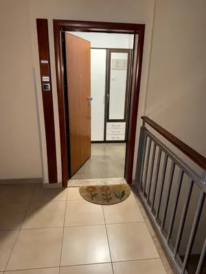 a hallway with a door and a mat on the floor at San apartment in Banja Luka