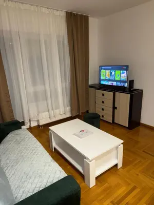 a living room with a couch and a table and a tv at San apartment in Banja Luka