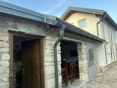 awning over a door of a building with a table at Stone House Ripac in Bihać