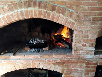 a brick oven with a fire in it at Stone House Ripac in Bihać