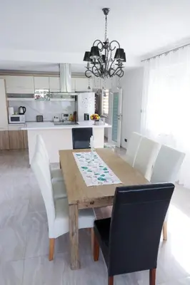 a kitchen and dining room with a wooden table and chairs at Villa Rio Verde in Bihać