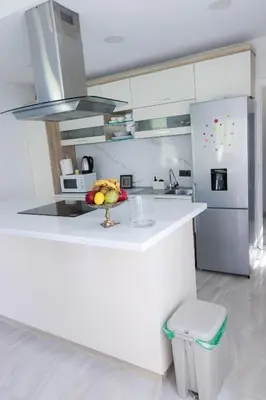 a white kitchen with a bowl of fruit on a counter at Villa Rio Verde in Bihać