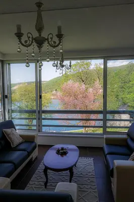 a living room with a couch and a large window at Villa Rio Verde in Bihać