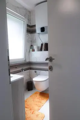 a bathroom with a toilet and a sink and a window at Villa Rio Verde in Bihać