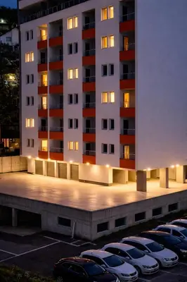 a parking lot with parked cars in front of a building at Muki Oaza Apartman in Tuzla